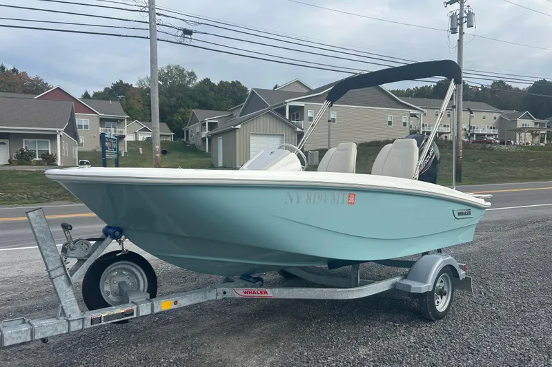 The Image of 2023 Boston Whaler 130 Super Sport boat on trailer, parked roadside. - 0