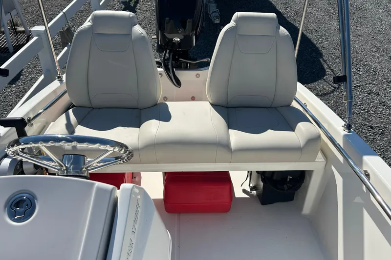Slide: The Image of 2023 Boston Whaler 130 Super Sport boat interior with dual seats and steering wheel. - 11