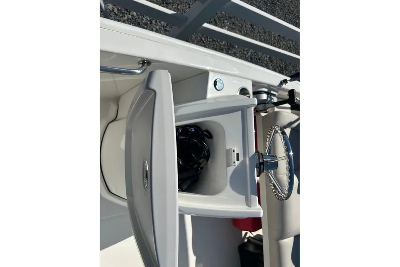 Slide: The Image of 2023 Boston Whaler 130 Super Sport boat console with open storage compartment. - 12