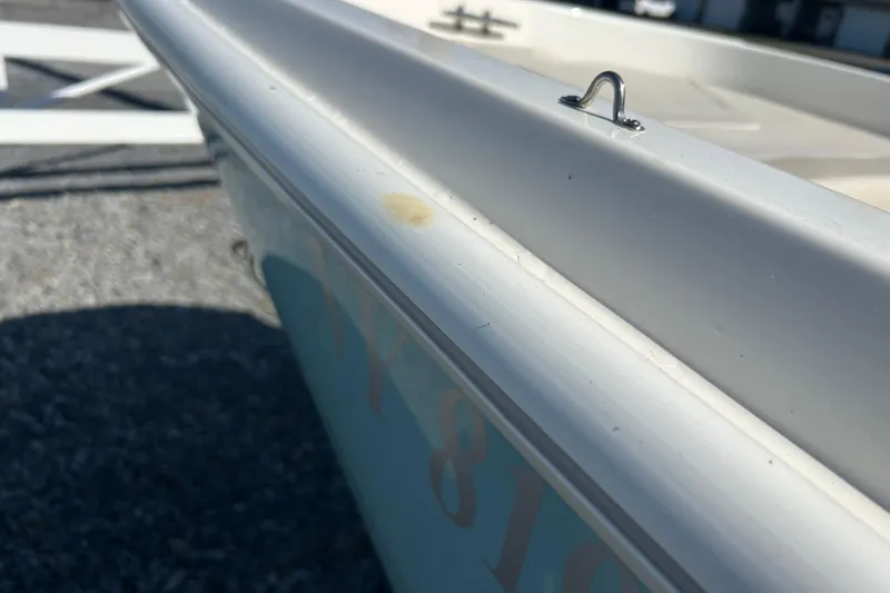 Slide: The Image of 2023 Boston Whaler 130 Super Sport boat detail, showing side rail and cleat. - 16