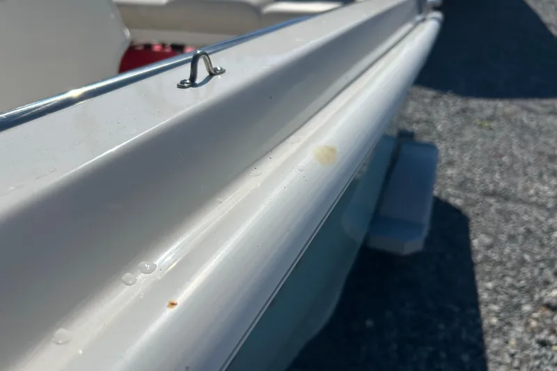 Slide: The Image of 2023 Boston Whaler 130 Super Sport boat detail, showing white hull and metal fitting. - 17