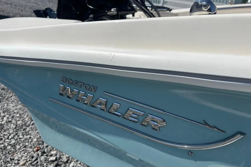 Slide: The Image of 2023 Boston Whaler 130 Super Sport boat side view with logo detail. - 20