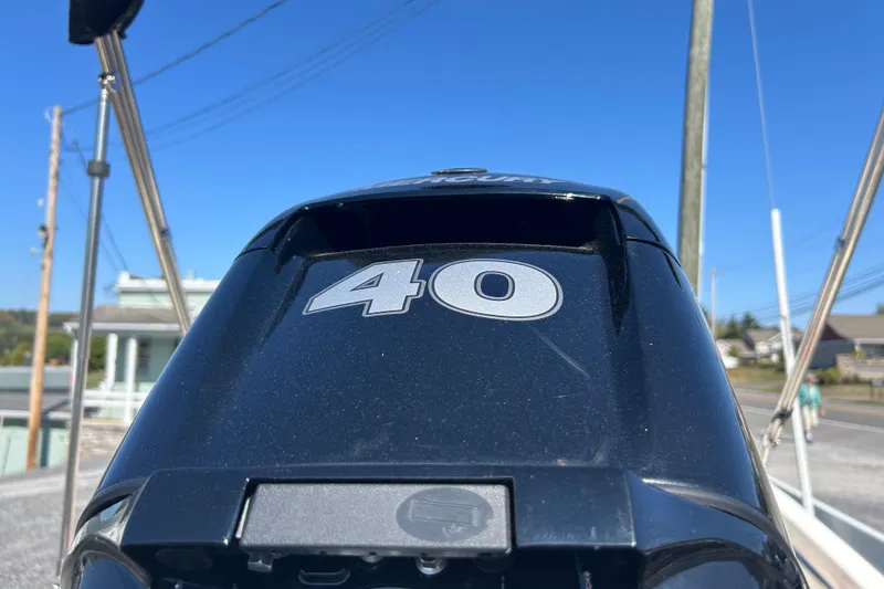 Slide: The Image of 2023 Boston Whaler 130 Super Sport outboard motor, 40 horsepower, under clear blue sky. - 21