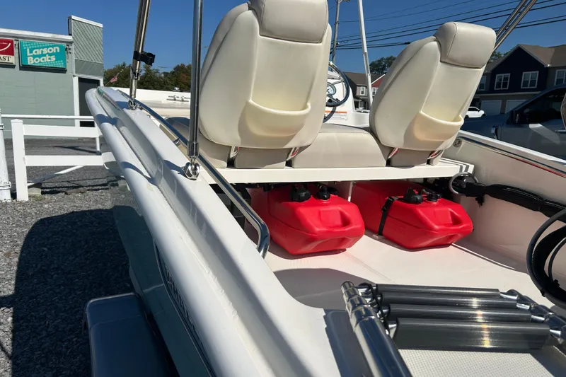 Slide: The Image of 2023 Boston Whaler 130 Super Sport interior with red fuel tanks and white seats. - 23