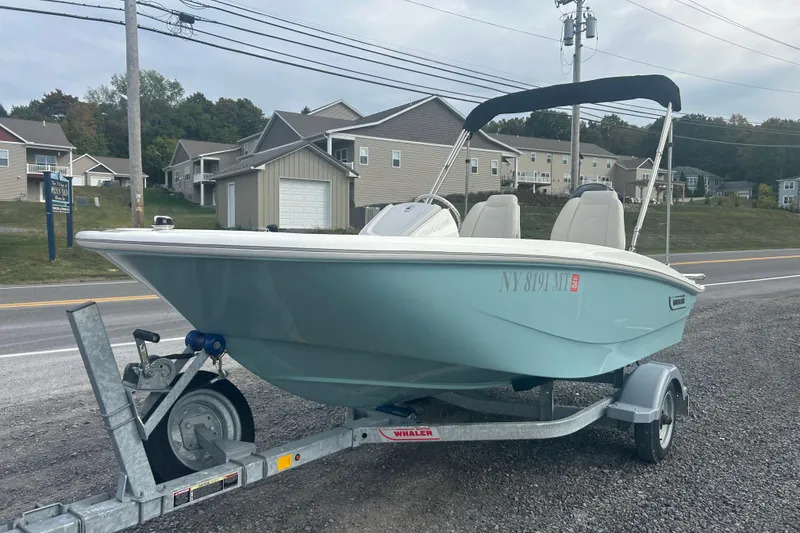 Slide: The Image of 2023 Boston Whaler 130 Super Sport boat on trailer, parked roadside. - 3