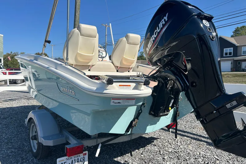 Slide: The Image of 2023 Boston Whaler 130 Super Sport boat with Mercury engine on trailer. - 5