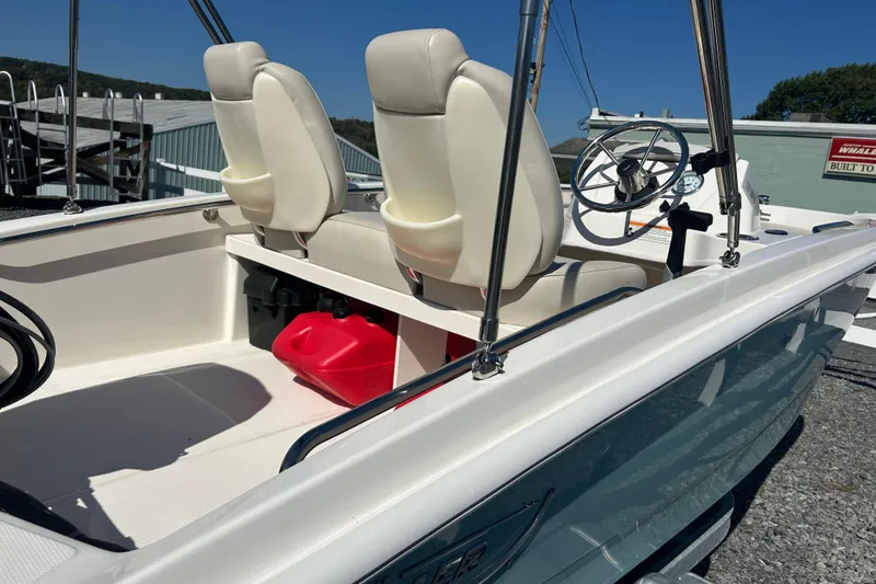 Slide: The Image of 2023 Boston Whaler 130 Super Sport boat interior with steering wheel and seats. - 9