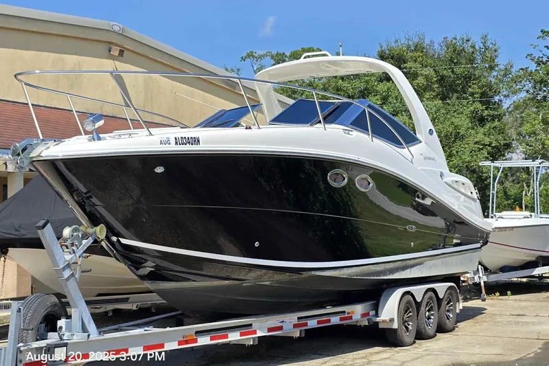 The Image of 2008 Sea Ray 290 Sundancer boat on trailer, parked outdoors. - 0