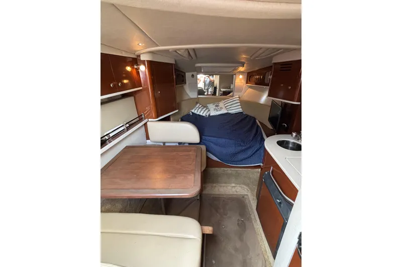 Slide: The Image of 2008 Sea Ray 290 Sundancer cabin interior with dining area and cozy sleeping space. - 21