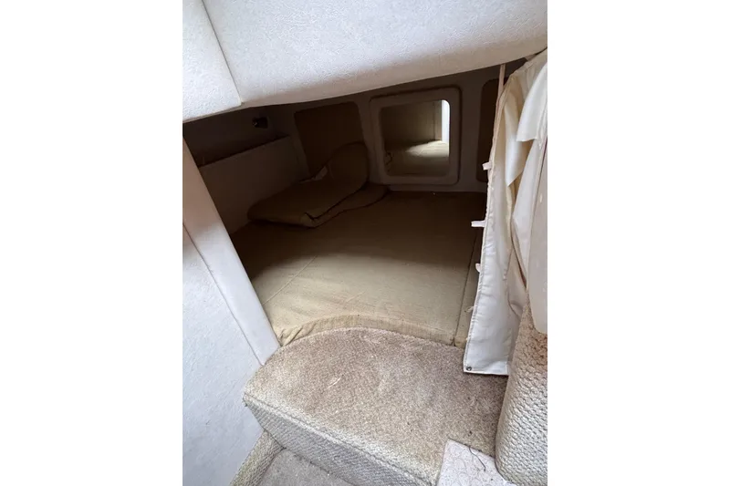 Slide: The Image of Interior cabin of 2008 Sea Ray 290 Sundancer with beige upholstery and compact sleeping area. - 24