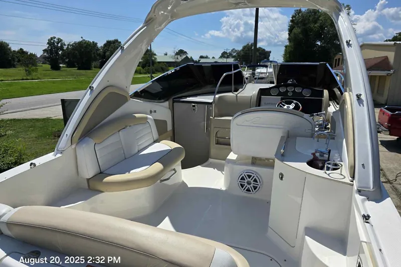 Slide: The Image of 2008 Sea Ray 290 Sundancer boat interior with seating and helm, photographed on a sunny day. - 4