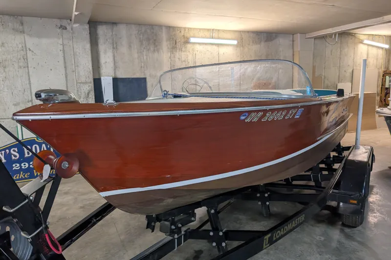 Slide: The Image of 1967 Chris-Craft 17 Sportsman boat on trailer in a garage setting. - 0