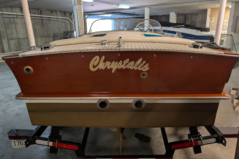 Slide: The Image of 1967 Chris-Craft 17 Sportsman boat in a garage, rear view with "Chrysalis" name. - 3