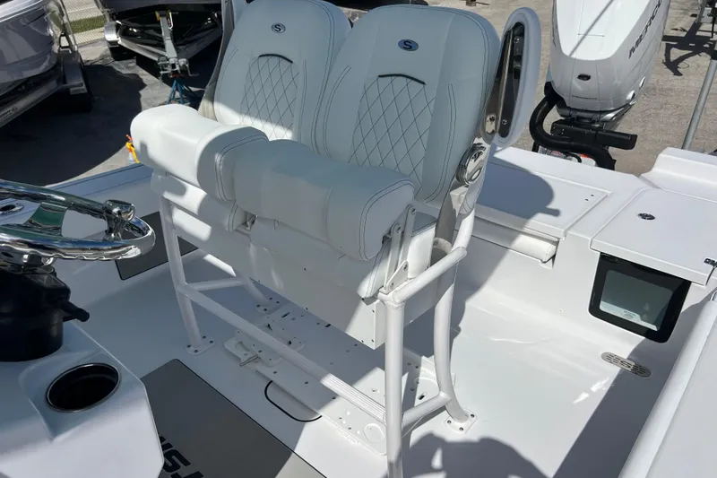 Slide: The Image of 2026 Sportsman Masters 247 Bay Boat helm with dual white seats and steering wheel. - 14