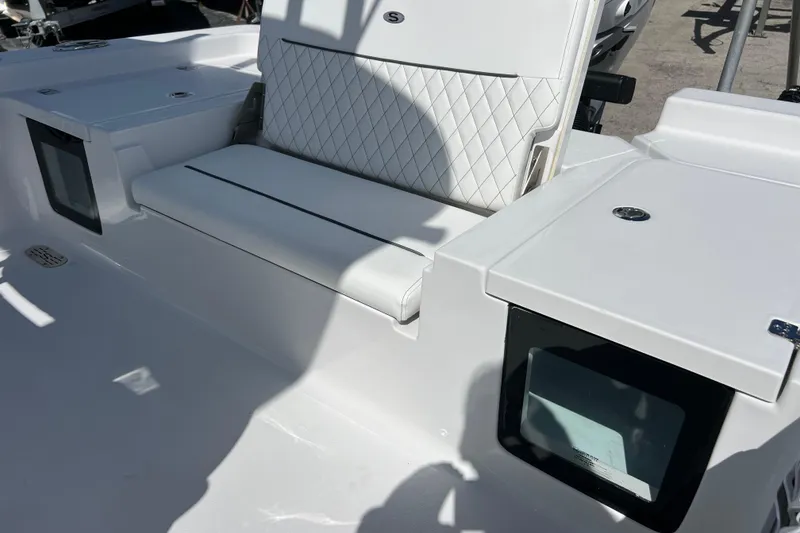 Slide: The Image of 2026 Sportsman Masters 247 Bay Boat interior with white seating and storage compartments. - 16