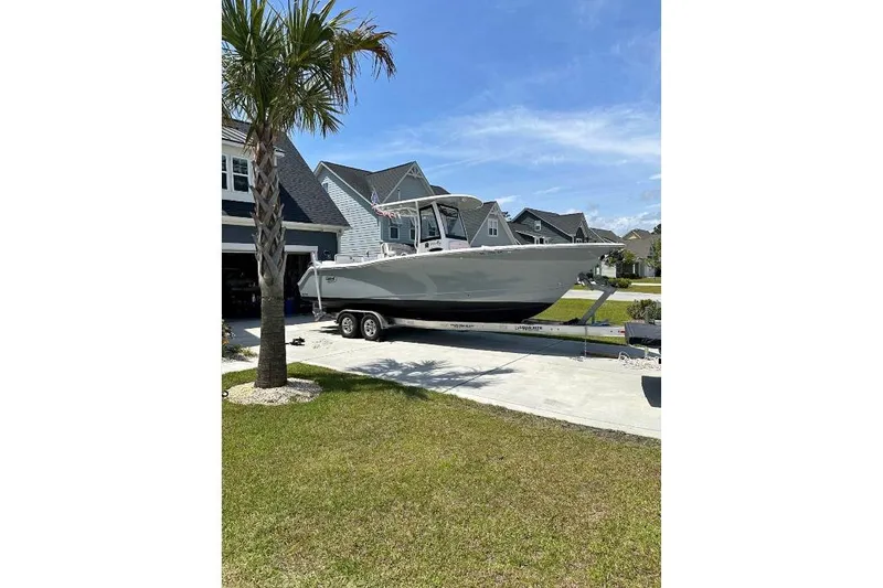 The Image of 2021 Sea Hunt Gamefish 27 boat on trailer in suburban driveway. - 0