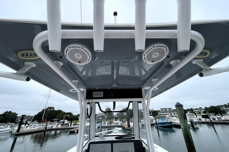 Slide: The Image of 2021 Sea Hunt Gamefish 27 boat console with speakers, docked in a marina. - 17