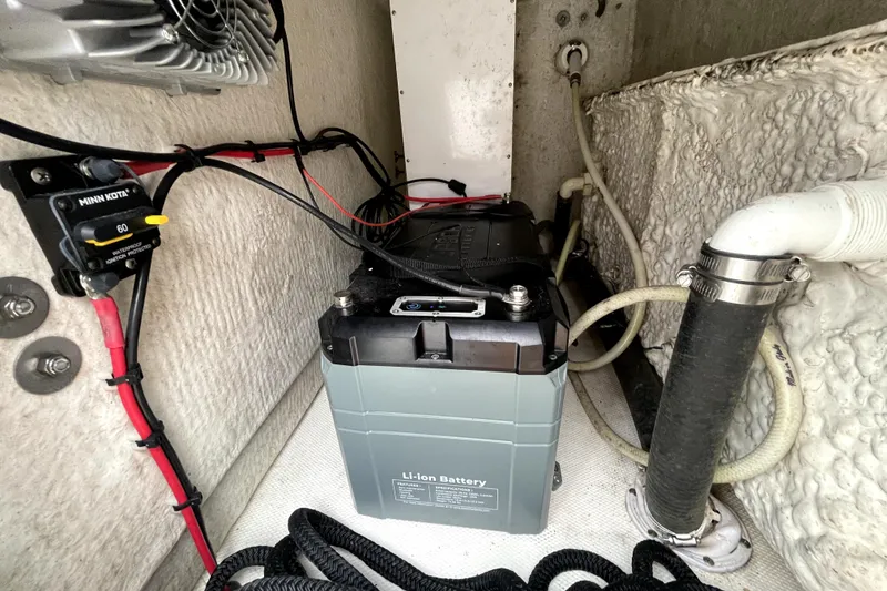 Slide: The Image of 2021 Sea Hunt Gamefish 27 battery compartment with lithium battery and wiring. - 23