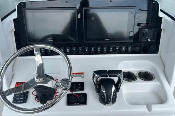 Slide: The Image of 2021 Sea Hunt Gamefish 27 boat with dual Yamaha engines in a marina setting. - 5