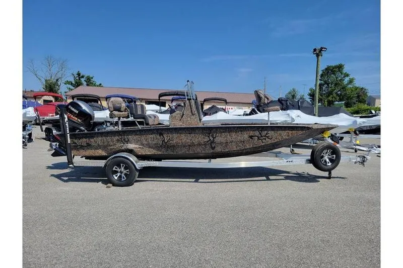 The Image of 2026 Xpress H20B Bay boat on trailer, parked outdoors under clear blue sky. - 1