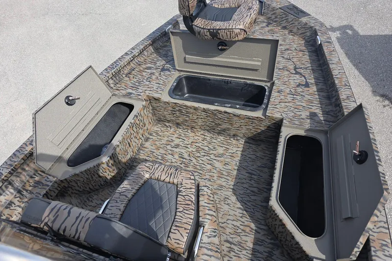 Slide: The Image of 2026 Xpress H20B Bay boat interior with camo design and storage compartments. - 10
