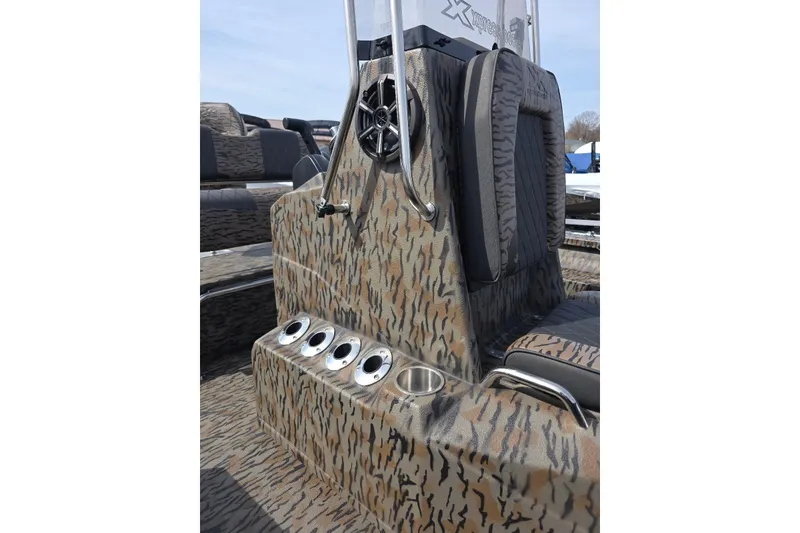 Slide: The Image of 2026 Xpress H20B Bay boat interior with camo design and cup holders. - 16
