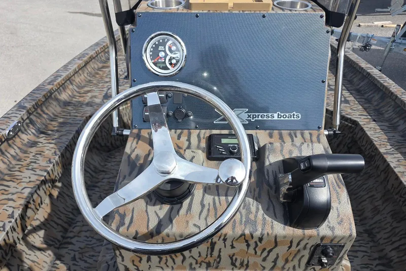 Slide: The Image of Steering console of 2026 Xpress H20B Bay boat with camo design and control panel. - 17