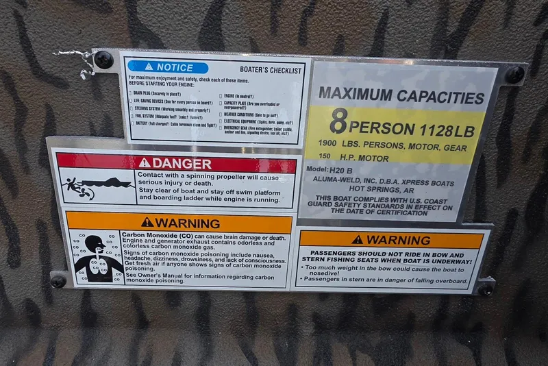 Slide: The Image of Safety and capacity labels on 2026 Xpress H20B Bay boat interior. - 19
