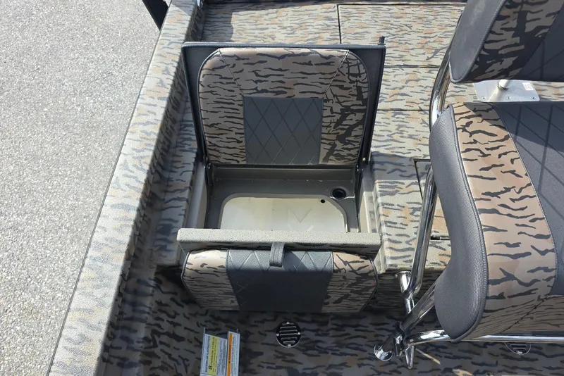 Slide: The Image of 2026 Xpress H20B Bay boat interior with camo-patterned seating and storage compartment. - 22