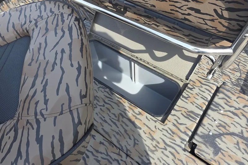 Slide: The Image of 2026 Xpress H20B Bay boat interior with camouflage seating and storage compartment. - 23