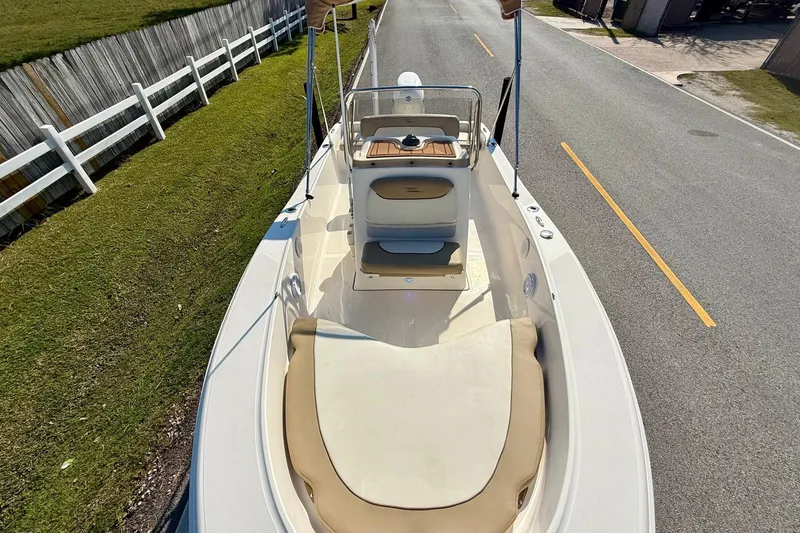 Slide: The Image of 2020 Pioneer 180 Sportfish boat on road, featuring spacious deck and seating. - 14