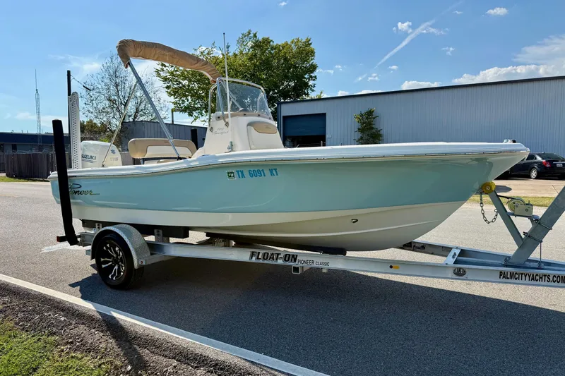 Slide: The Image of 2020 Pioneer 180 Sportfish boat on trailer, parked outdoors under clear sky. - 5
