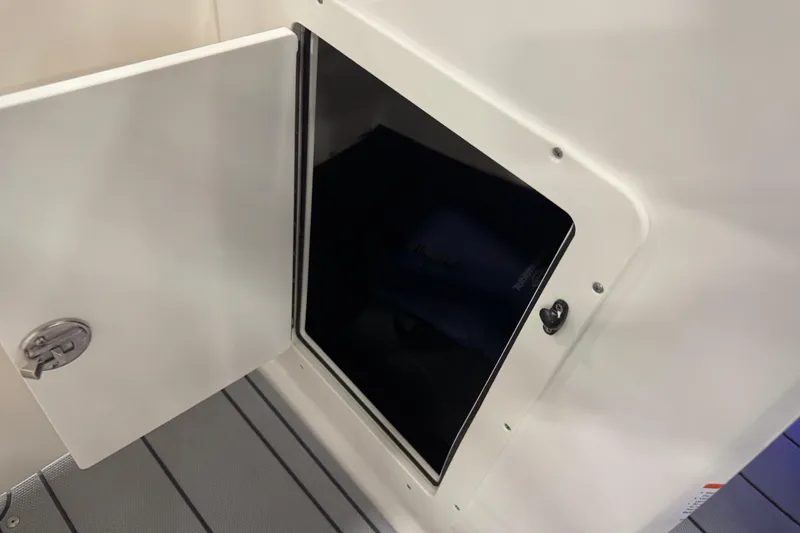 Slide: The Image of Open storage compartment on 2026 Chaparral 21 SSi boat, featuring sleek white design. - 16