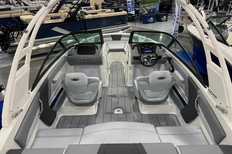 Slide: The Image of 2026 Chaparral 21 SSi boat interior with modern seating and dashboard at a showroom. - 25