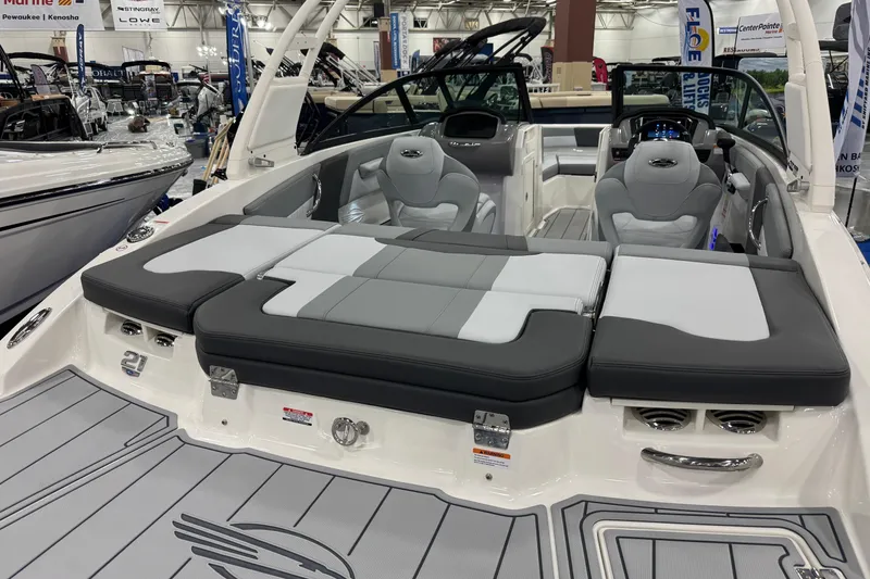 Slide: The Image of 2026 Chaparral 21 SSi boat interior with gray seating and modern dashboard at a boat show. - 26