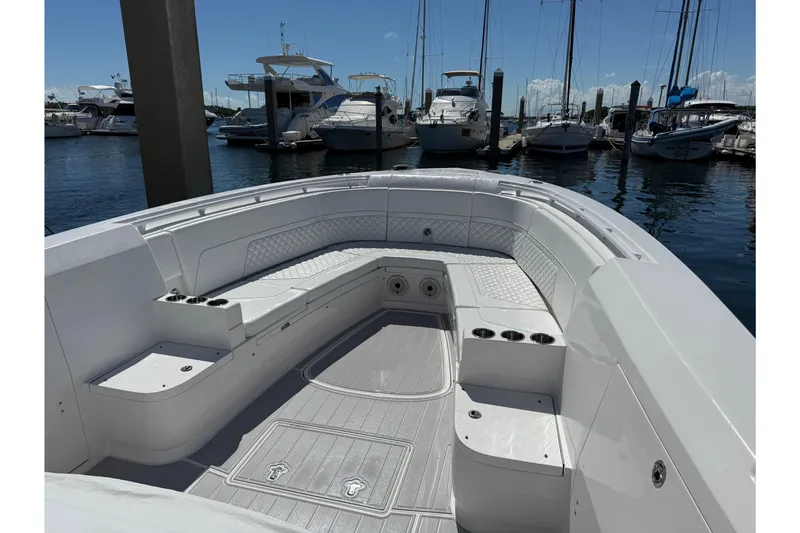 Slide: The Image of 2020 Intrepid 375 Nomad FE boat docked at marina, featuring sleek design and spacious deck. - 2
