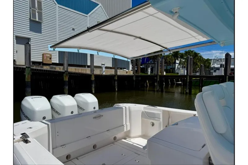 Slide: The Image of 2020 Intrepid 375 Nomad FE boat docked at marina, blue and white design. - 9