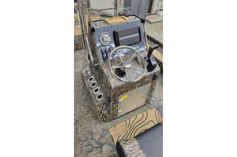 Slide: The Image of 2026 Xpress H20B Bay boat interior with camo design and rod holders. - 18