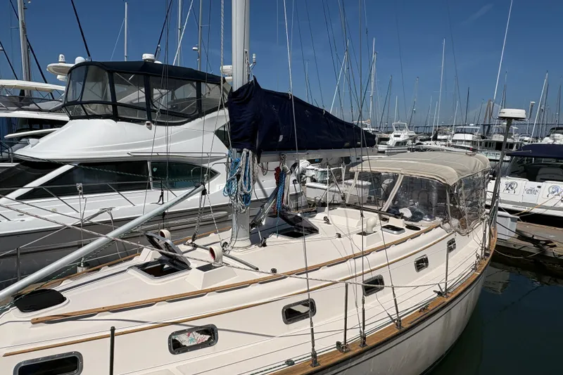 Slide: The Image of 1995 Island Packet 40 sailboat docked at marina, surrounded by other boats. - 10