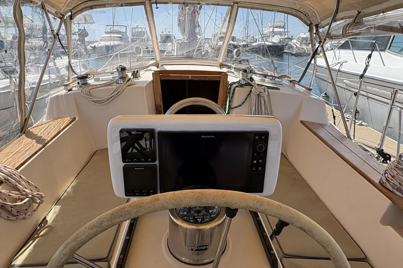 Slide: The Image of Cockpit of 1995 Island Packet 40 sailboat with navigation equipment and marina view. - 18