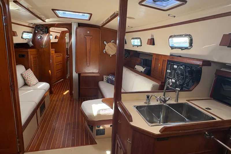 Slide: The Image of Interior of a 1995 Island Packet 40 sailboat with wood finishes and cozy seating. - 22