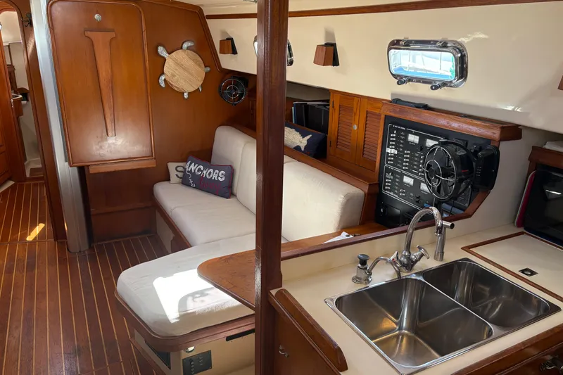 Slide: The Image of Interior of 1995 Island Packet 40 sailboat with wood accents and cozy seating area. - 23