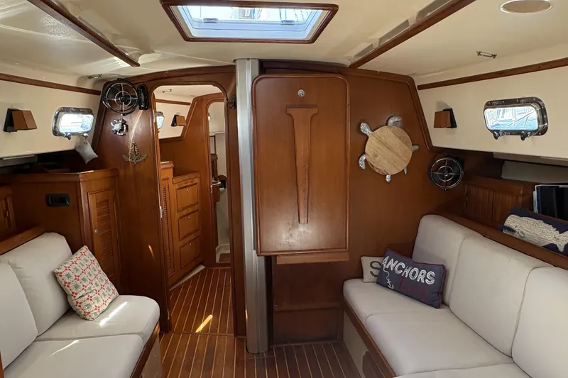 Slide: The Image of Interior of a 1995 Island Packet 40 sailboat with wooden cabinetry and cozy seating. - 25