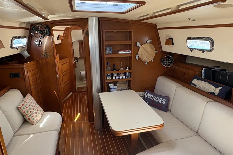 Slide: The Image of Interior of a 1995 Island Packet 40 sailboat with cozy seating and nautical decor. - 26