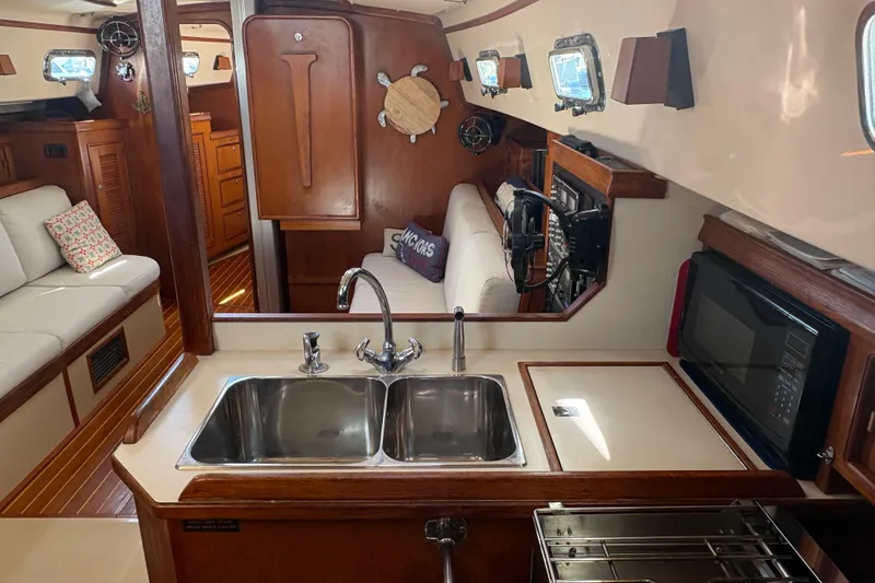 Slide: The Image of Interior of 1995 Island Packet 40 sailboat with kitchen and seating area. - 32