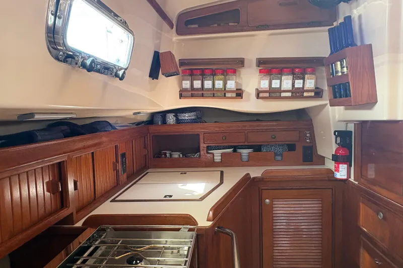Slide: The Image of Interior of 1995 Island Packet 40 sailboat kitchen with wooden cabinetry and spice rack. - 36
