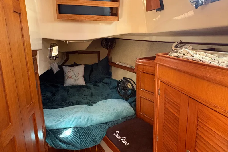 Slide: The Image of Aft cabin of a 1995 Island Packet 40 sailboat with wooden cabinetry and bedding. - 38