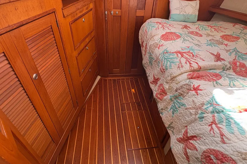 Slide: The Image of Cozy cabin interior of 1995 Island Packet 40 sailboat with wooden cabinetry and nautical bedding. - 45