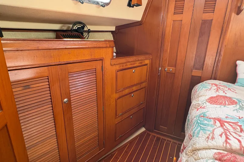 Slide: The Image of Cozy 1995 Island Packet 40 yacht cabin with wooden cabinetry and nautical-themed bedding. - 46