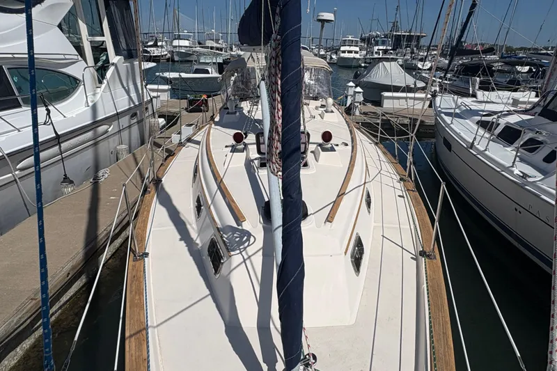Slide: The Image of 1995 Island Packet 40 sailboat docked at a marina, surrounded by other boats. - 8